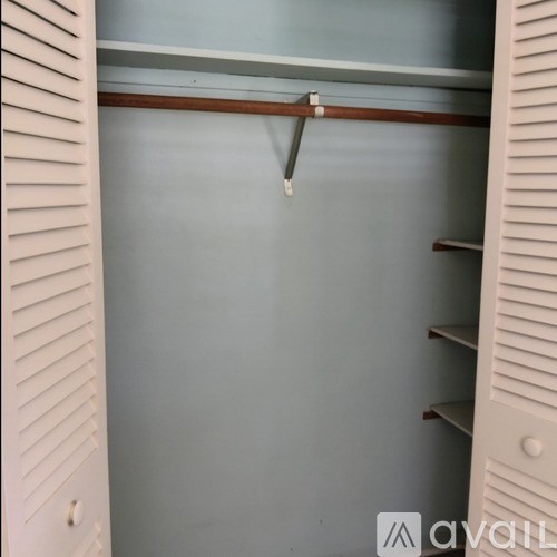 A white closet with a shelf and a hanger.