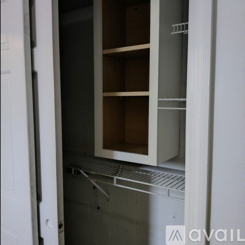 A white refrigerator with the door open and empty.