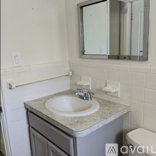 A bathroom with a sink, mirror, and toilet.