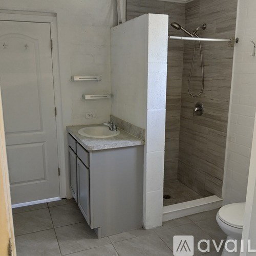 A bathroom with a sink, toilet, and shower.