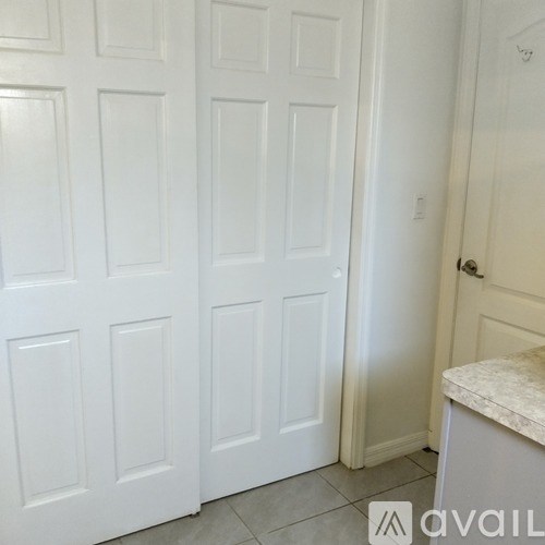 A white door with a silver handle is in a room.