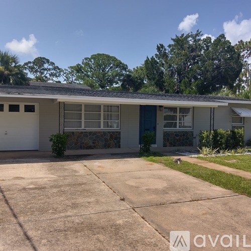 A house with a stone wall and a blue door.