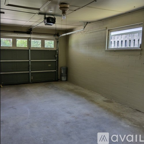 A spacious garage with a closed door and a window.