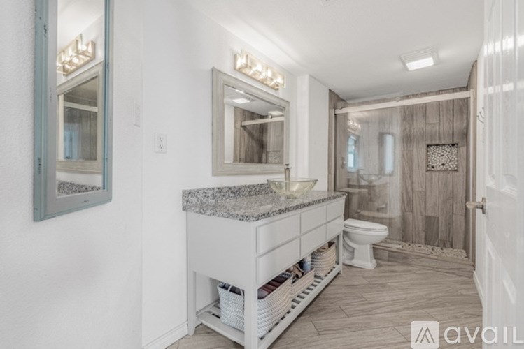 A bathroom with a marble countertop and a large mirror.