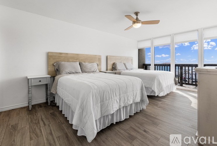 A bedroom with two beds and a ceiling fan.