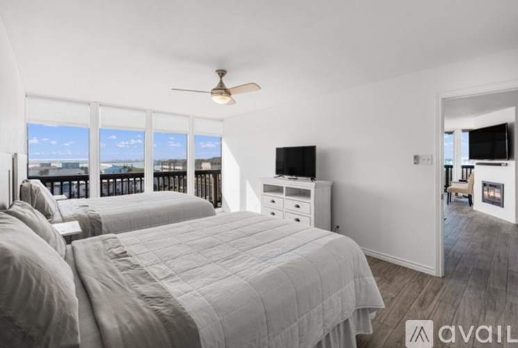 A bedroom with two beds and a television.