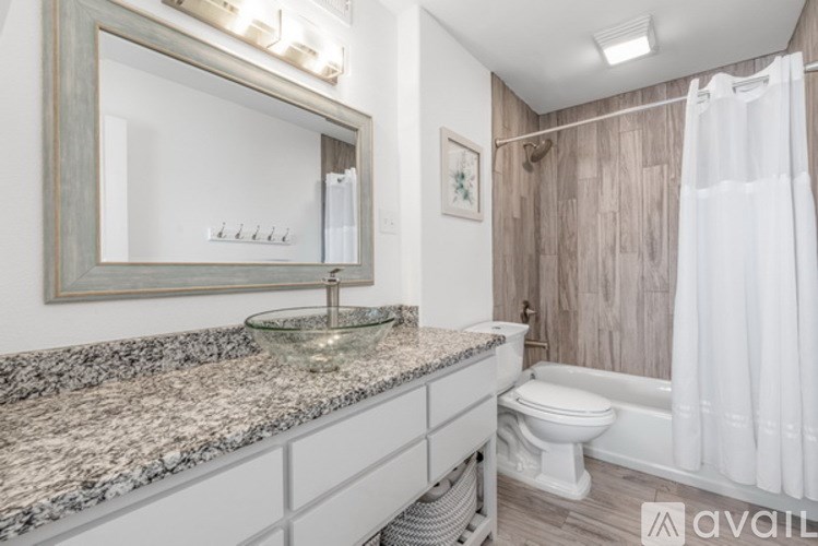 A bathroom with a granite countertop and a white toilet.