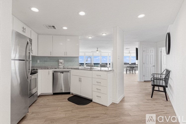 A kitchen with white cabinets and a stainless steel refrigerator.