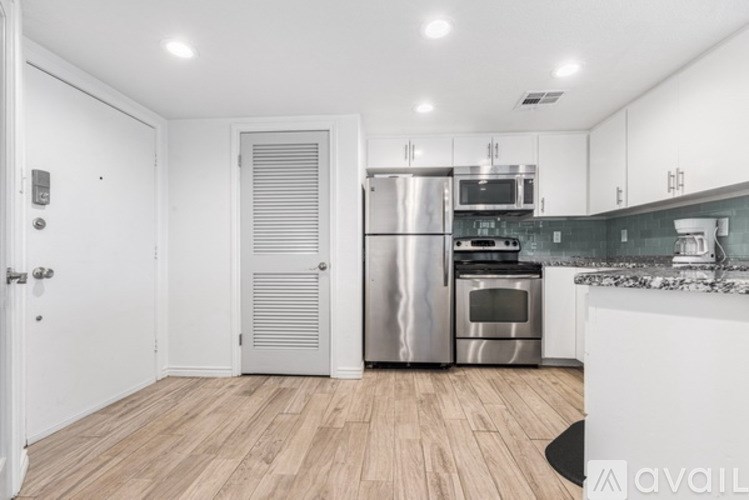 A kitchen with a refrigerator, oven, and microwave.