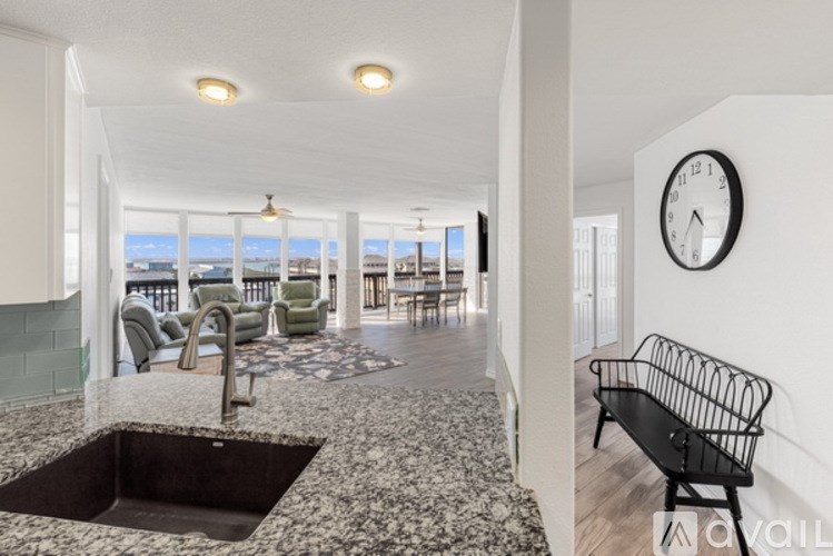 A modern kitchen with a large window overlooking the sea.