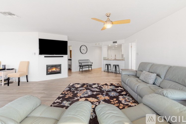 A living room with a grey sofa and a fireplace.