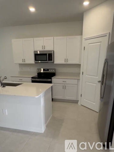 A kitchen with white cabinets and appliances.
