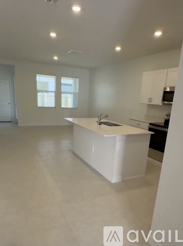 A white kitchen with a large island in the middle.