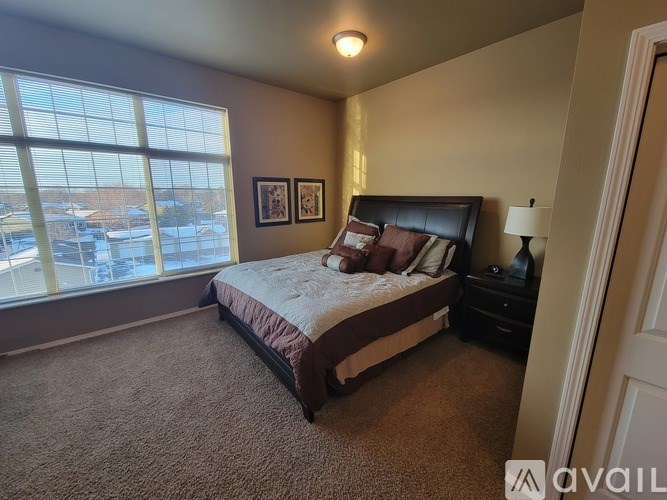 A bedroom with a large bed and a window overlooking a parking lot.
