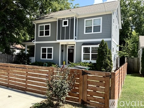 A grey house with a white van parked in front.