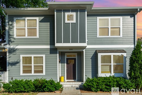 A kitchen with white cabinets and a brick backsplash is available for rent.