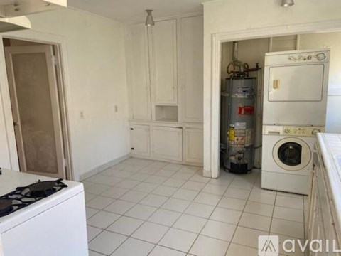 A kitchen with white cabinets and a white stove.