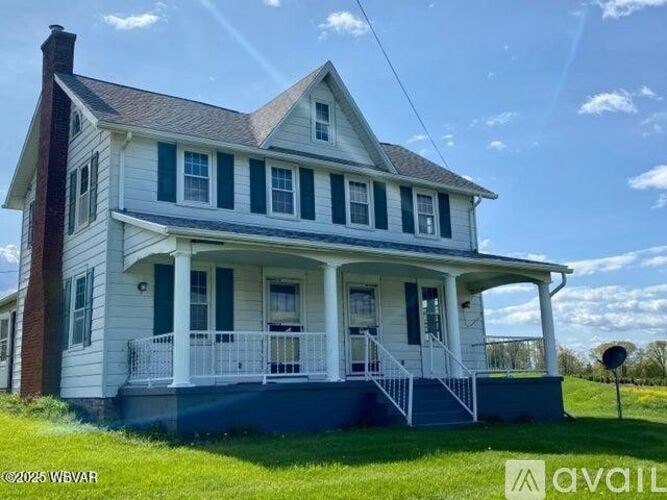 A two-story house with a front porch and a satellite dish on the roof.