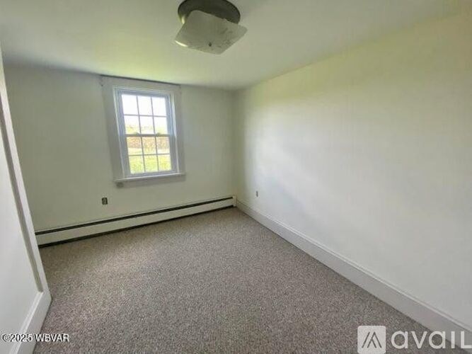 A room with a window and carpeted floor.