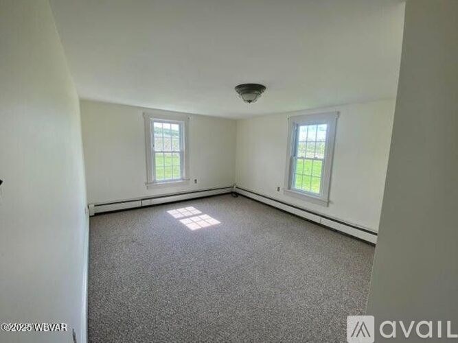 A room with two windows and carpeted floor.