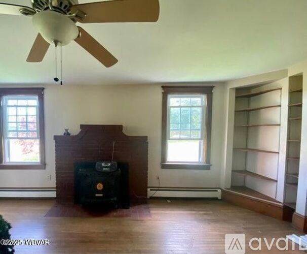 A room with a fireplace and a ceiling fan.