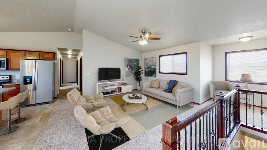 A living room with a couch, chairs, and a television.