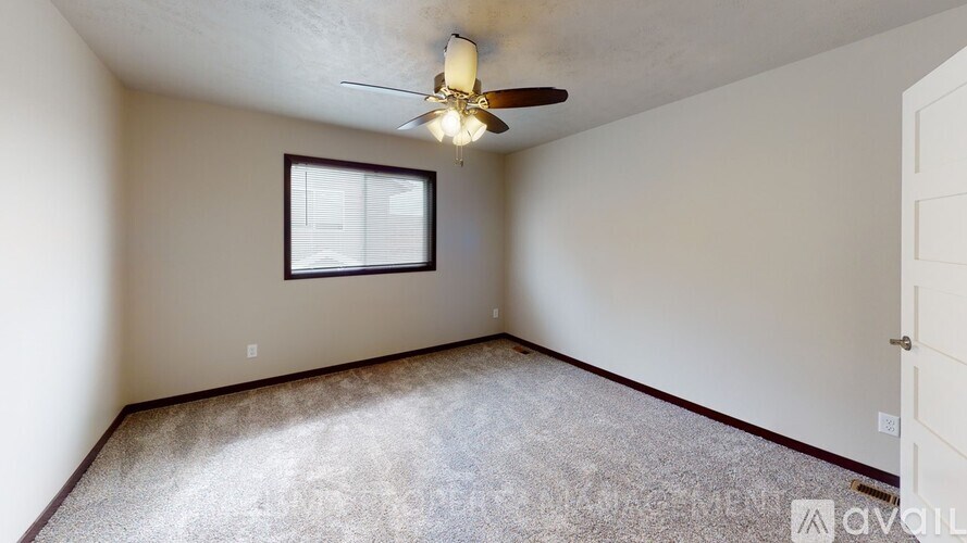 A room with a ceiling fan and a window.