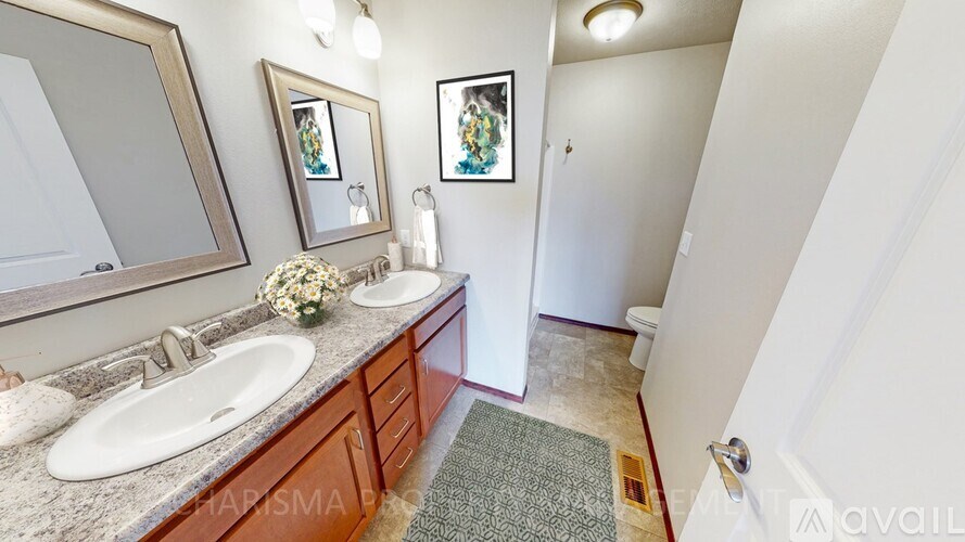 A bathroom with a sink, mirror, and two pictures on the wall.