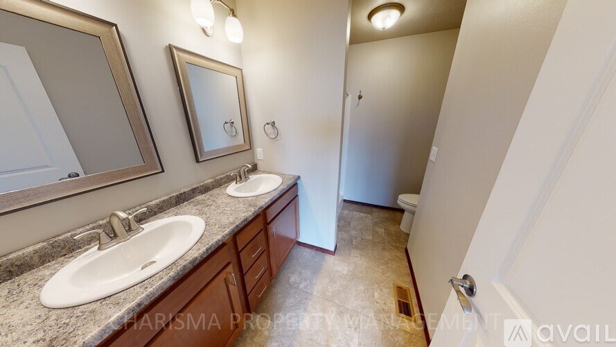 A bathroom with two sinks and a large mirror.