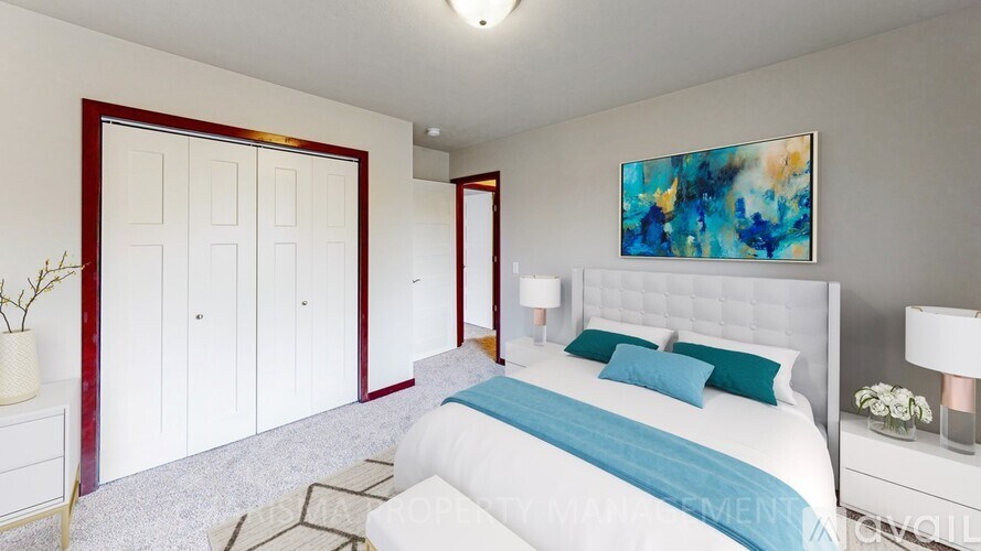 A bedroom with a large bed and a painting on the wall.