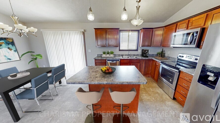 A kitchen with a table and chairs in front of it.