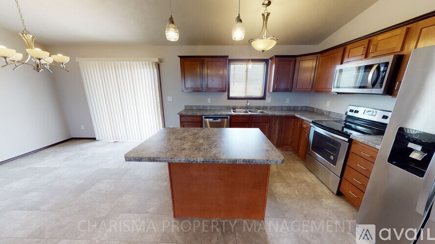 A kitchen with wooden cabinets and a granite countertop.