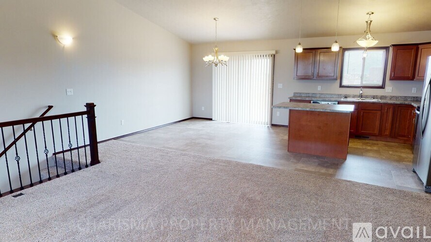 A spacious living area with a kitchen and dining area in the background.