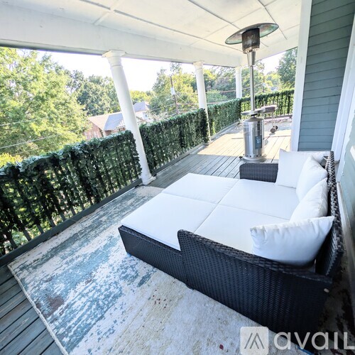 A white couch is on a porch with a white ceiling.