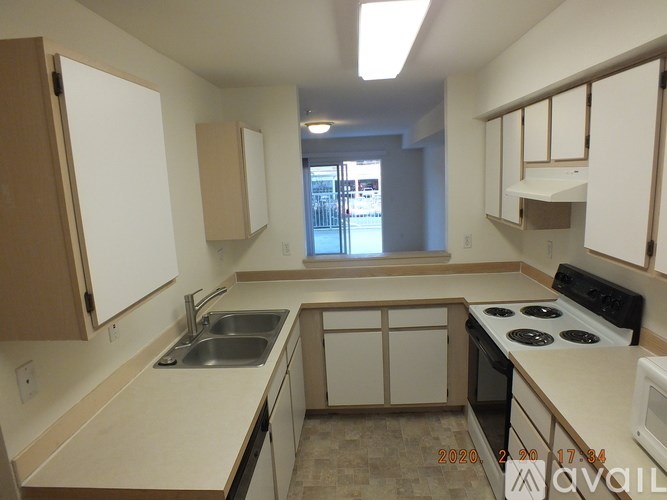 A kitchen with white cabinets and a stove top oven.