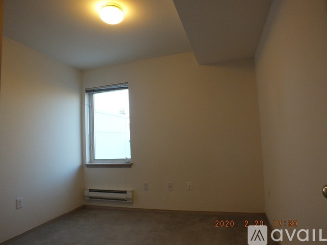 A room with a window and a wall-mounted air conditioner unit.