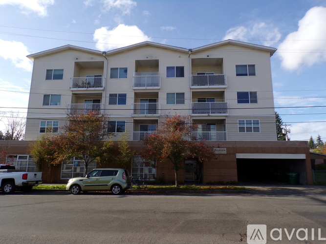 A two-story apartment building with a parking lot in front.