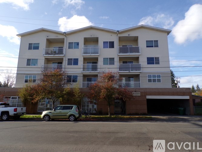 A two-story apartment building with a parking lot in front.
