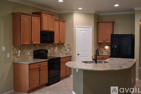 A kitchen with brown cabinets and black appliances.