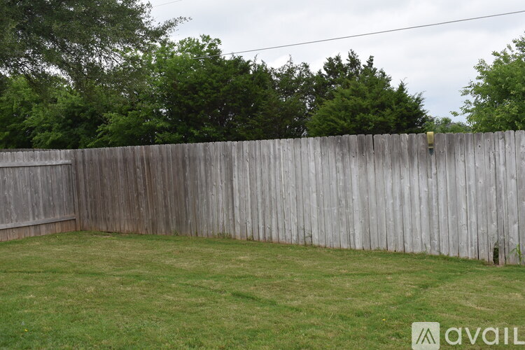 A wooden fence encloses a grassy yard.