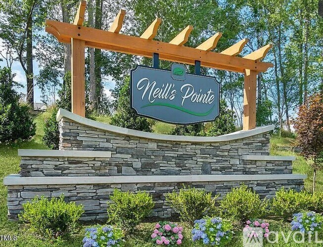 A sign that reads "nell's Pointe" is mounted on a wooden structure.