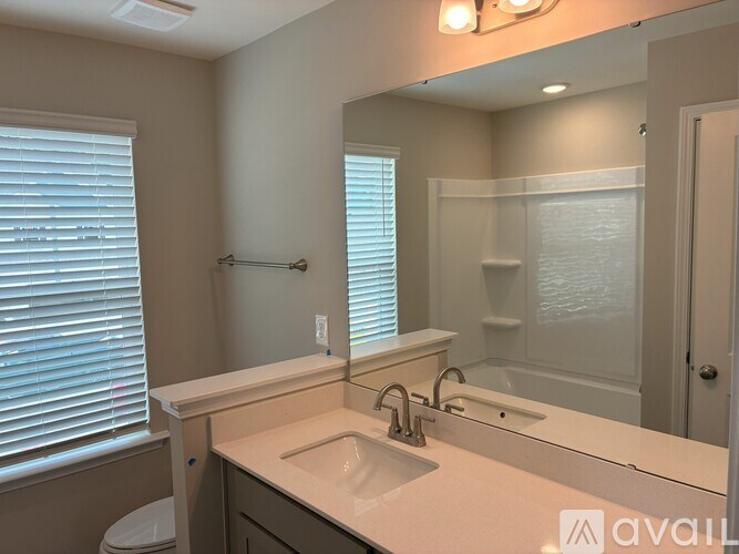 A bathroom with a sink, mirror, and toilet.