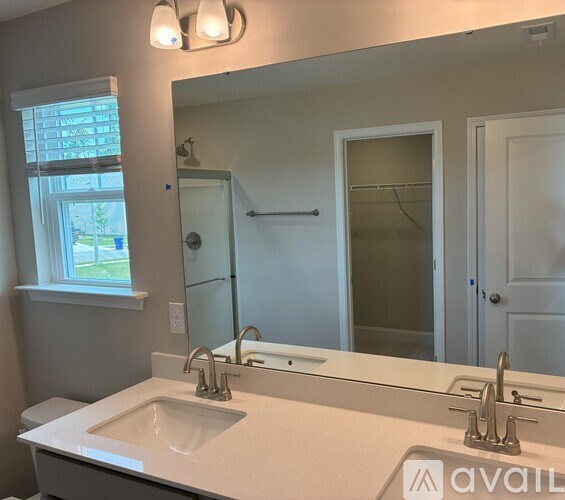 A bathroom with a white sink and a large mirror.