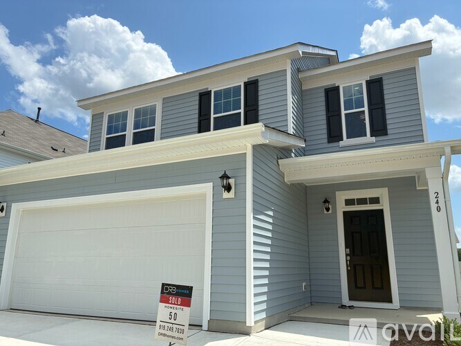 A house with a garage door is for sale at $50,000.