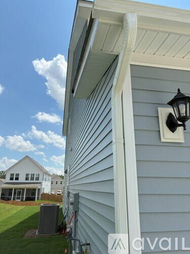 A house with a white trim and a black lamp on the wall.