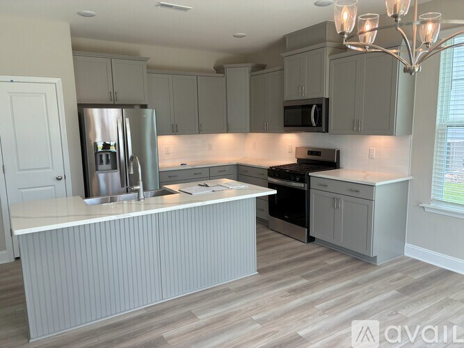 A kitchen with a refrigerator, stove, and microwave.