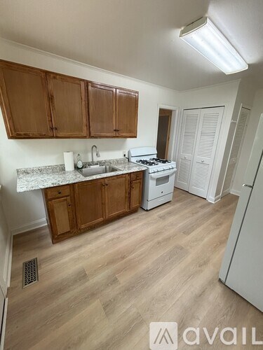 A kitchen with wooden cabinets and a white fridge.
