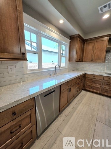 A kitchen with wooden cabinets and a marble countertop.