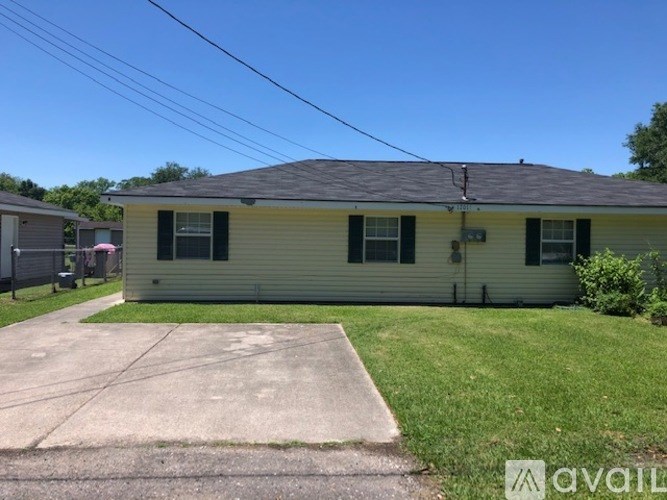 A house with a green lawn and a grey roof.