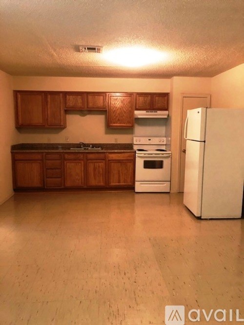 A kitchen with wooden cabinets and a white refrigerator.